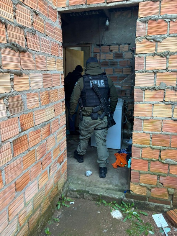 Policiais dentro de residência durante cumprimento de mandados