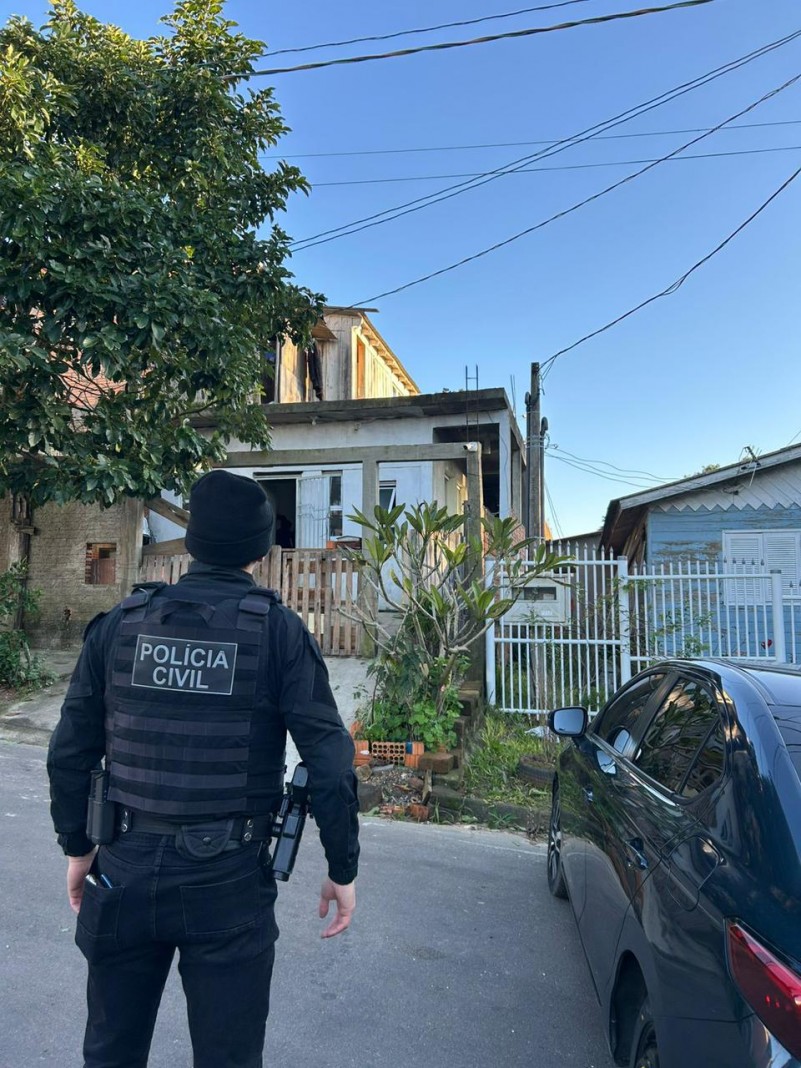 Policial civil em frente a residência durante cumprimento de mandados